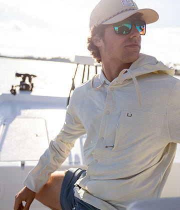 Angler wearing Huk performance fishing apparel on the water