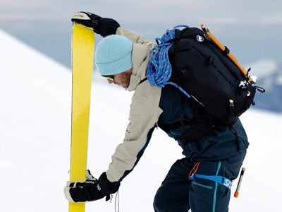 Skier attaching POMOCA climbing skins in the snow